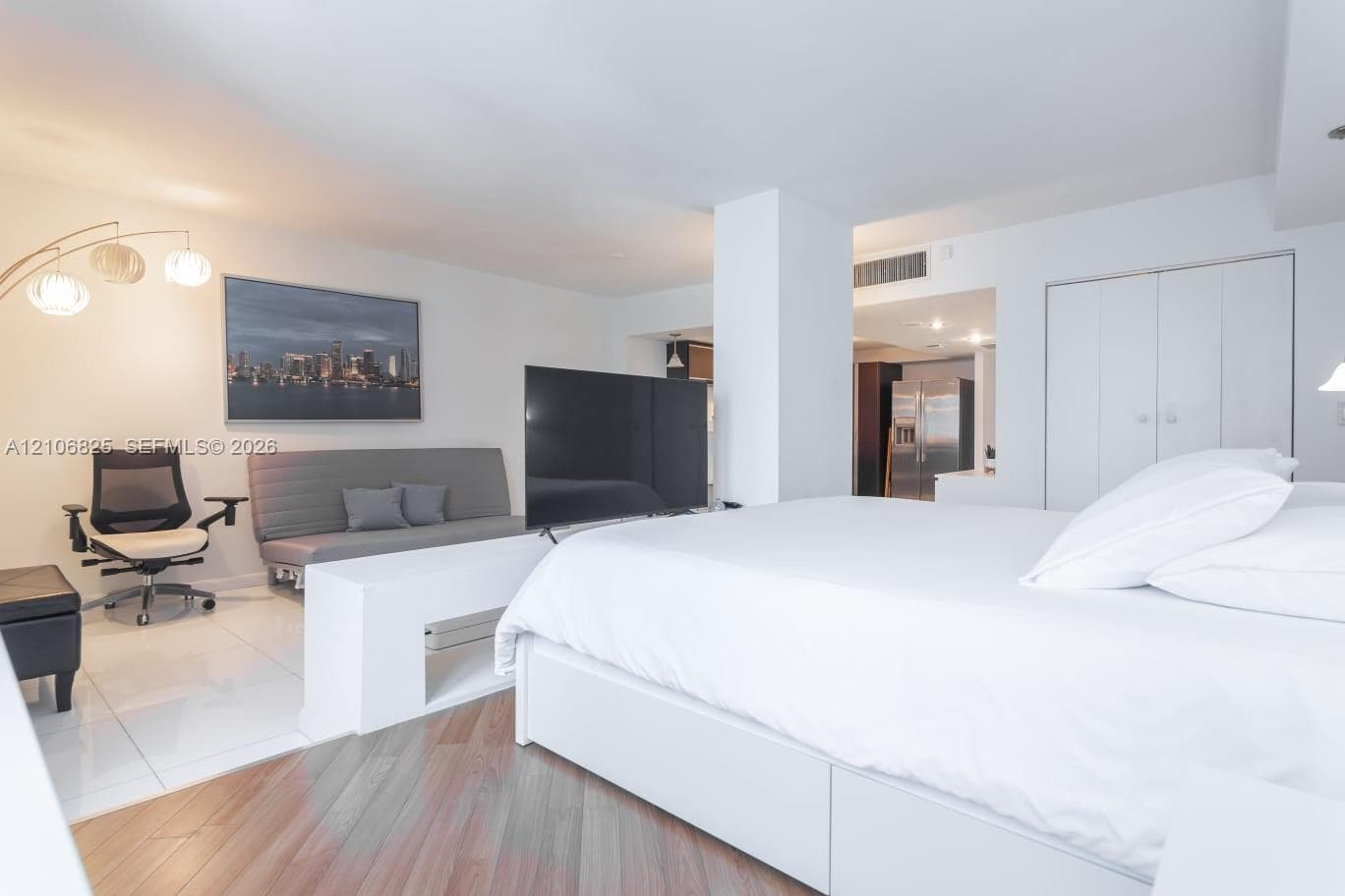 Spacious interior featuring a combination of polished tile and wood-finish flooring, a central structural support pillar, built-in storage cabinetry, and recessed lighting