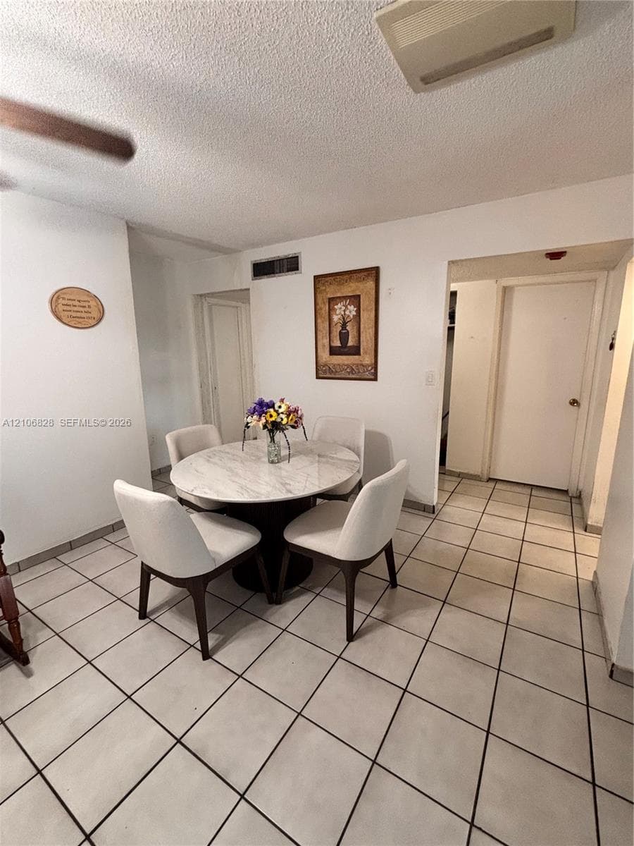 Interior area featuring large-format ceramic tile flooring, neutral wall finishes, and a ceiling-mounted fan
