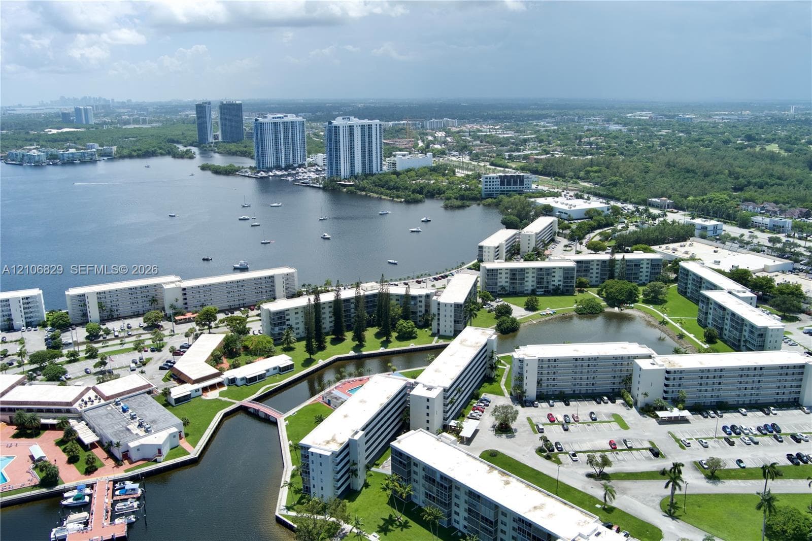 Aerial perspective of a multi-building residential community featuring waterfront access, private boat docks, and maintained green space