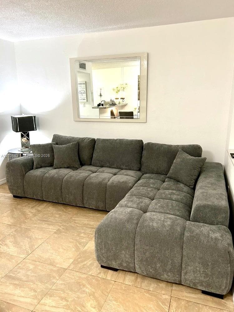 Neutral tile flooring and a wall-mounted rectangular mirror with a white frame