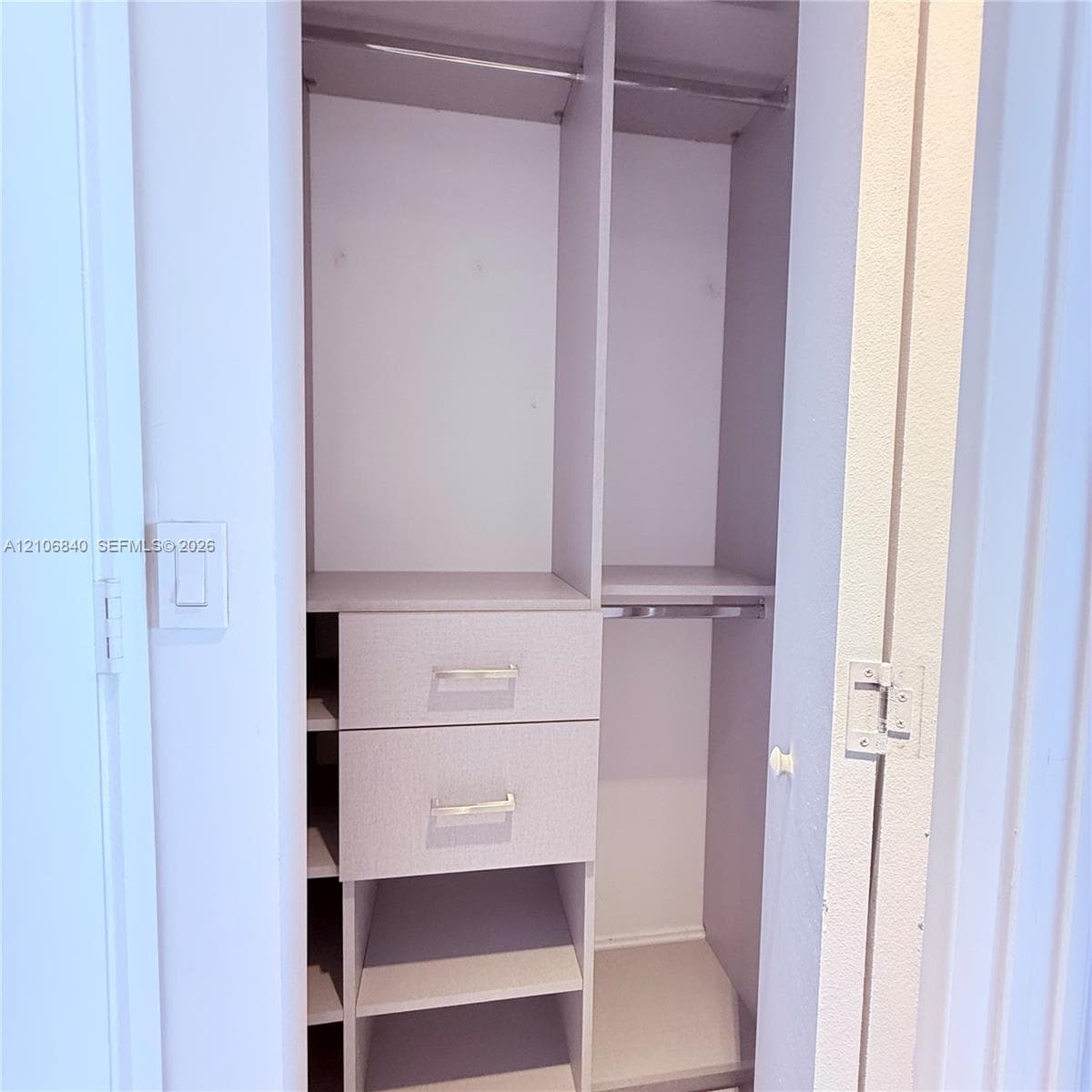 Custom storage system featuring two stacked drawers, open shelving, and integrated hanging rods with metal hardware