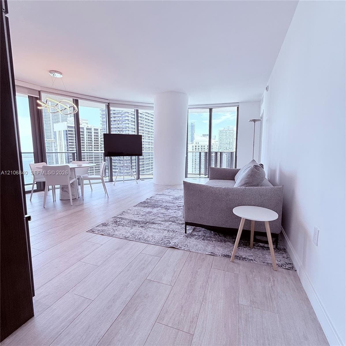 Floor-to-ceiling windows, wood-finish tile flooring, recessed ceiling lighting, and contemporary pendant fixture