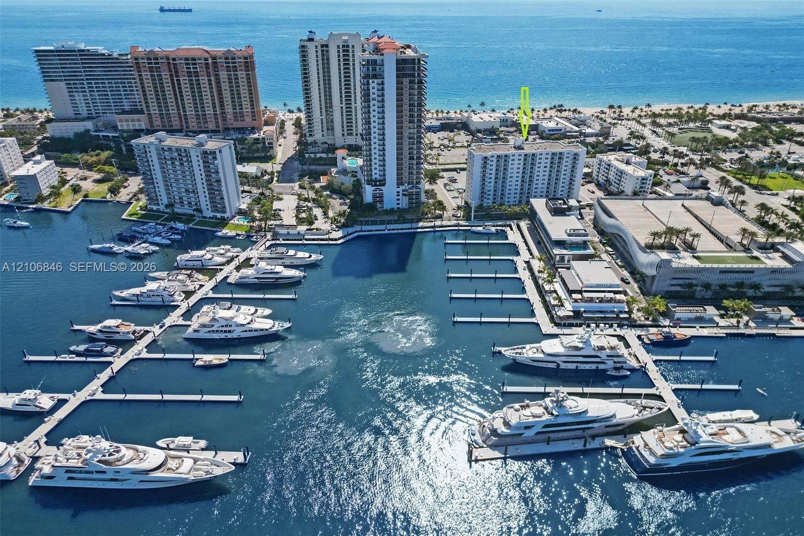 Aerial perspective of coastal residential property featuring proximity to a marina and shoreline