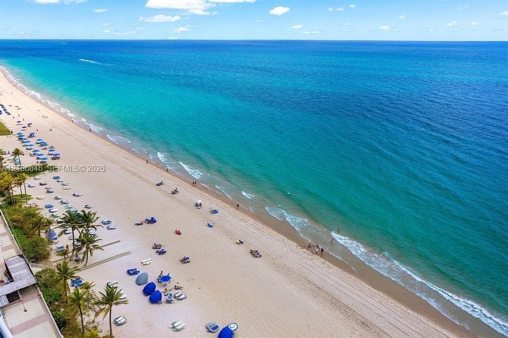 Direct oceanfront location featuring extensive sandy beach access and mature palm trees