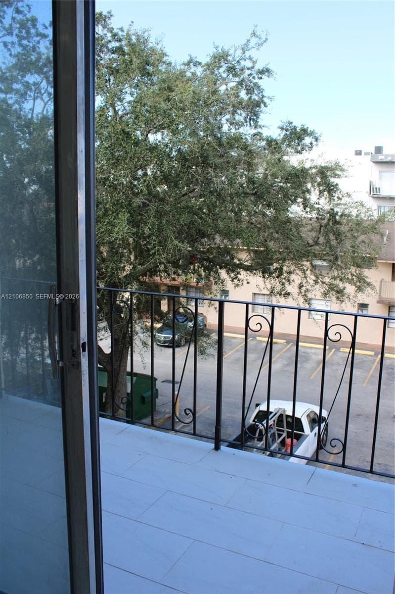 Private balcony featuring light-toned tile flooring and metal scrollwork railing