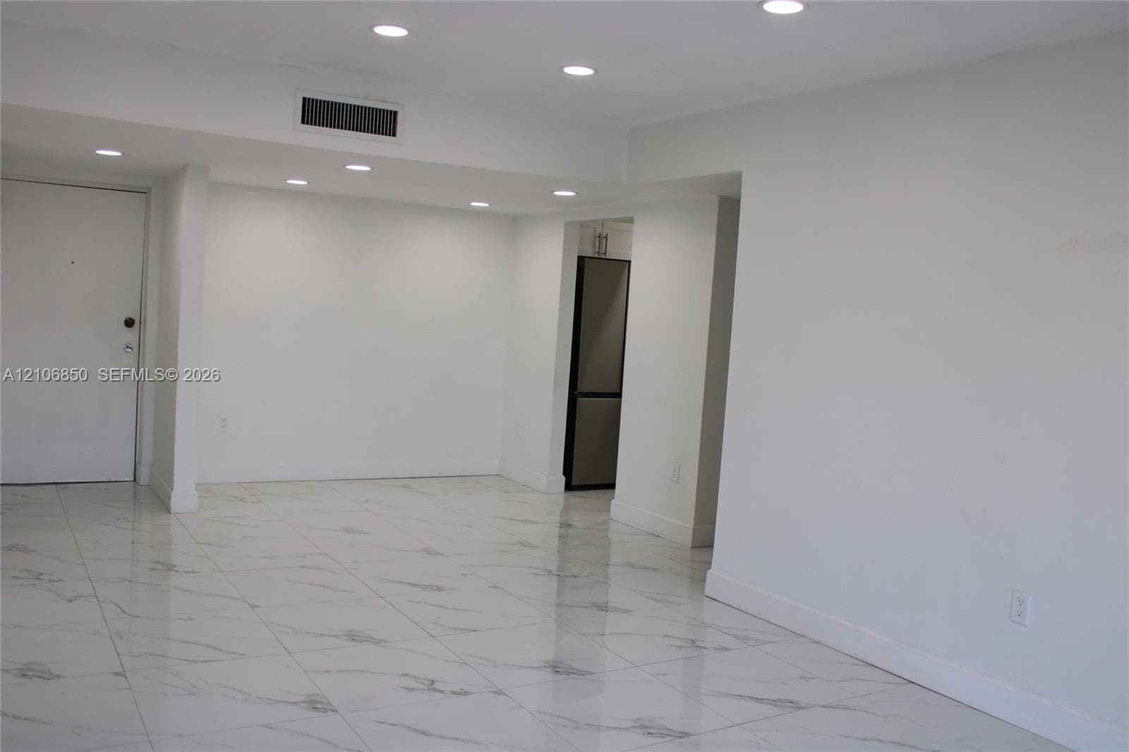 Neutral-toned interior featuring large-format polished tile flooring and recessed LED lighting