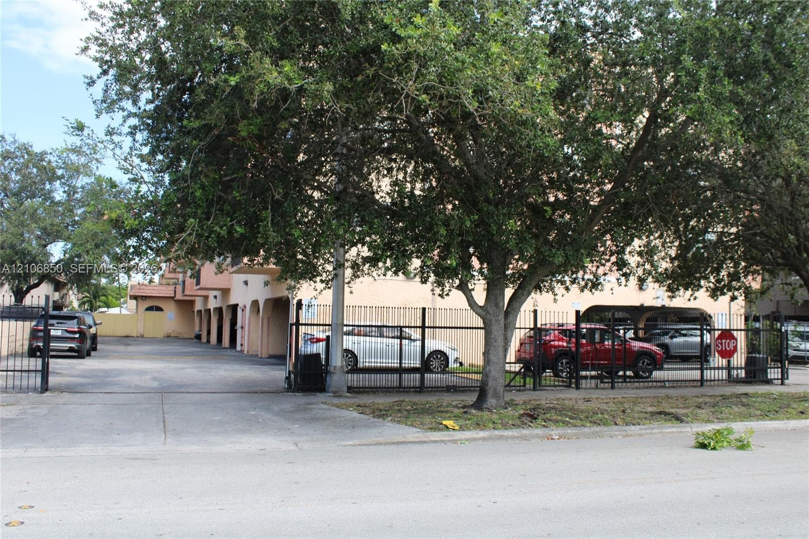 Gated parking area featuring covered parking spaces and perimeter iron fencing