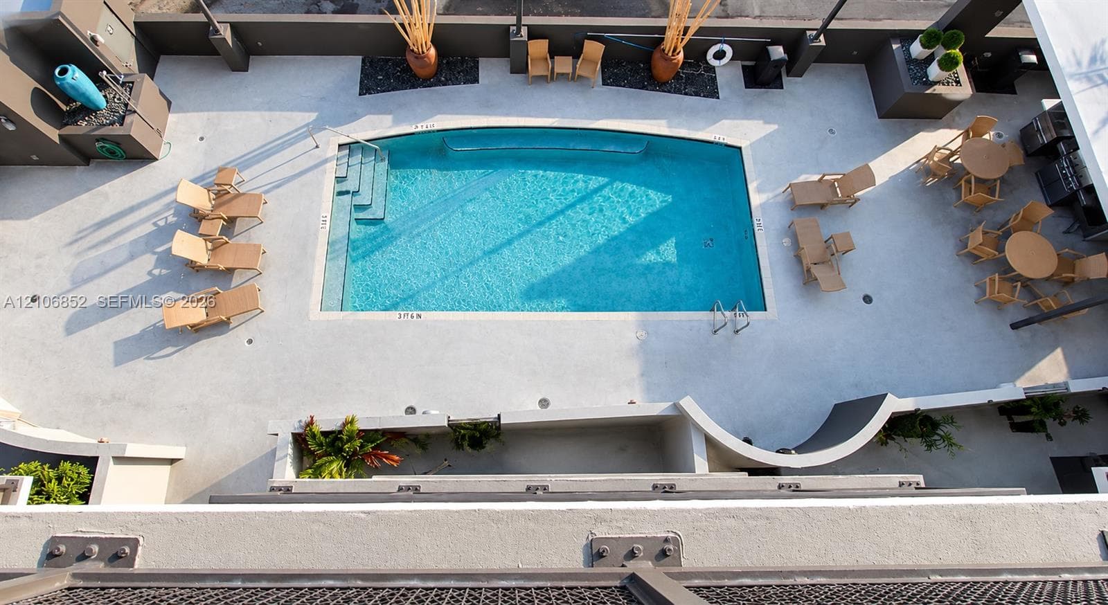 Elevated swimming pool featuring a concrete deck, built-in recessed wall planters, and integrated hardscaping