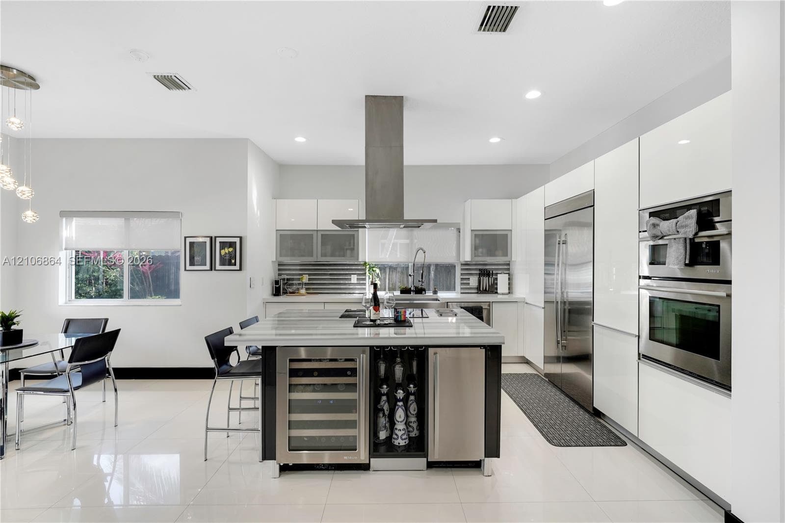 Walk-in closet featuring floor-to-ceiling built-in dark wood cabinetry, extensive shelving, integrated drawer storage, and a central chandelier fixture