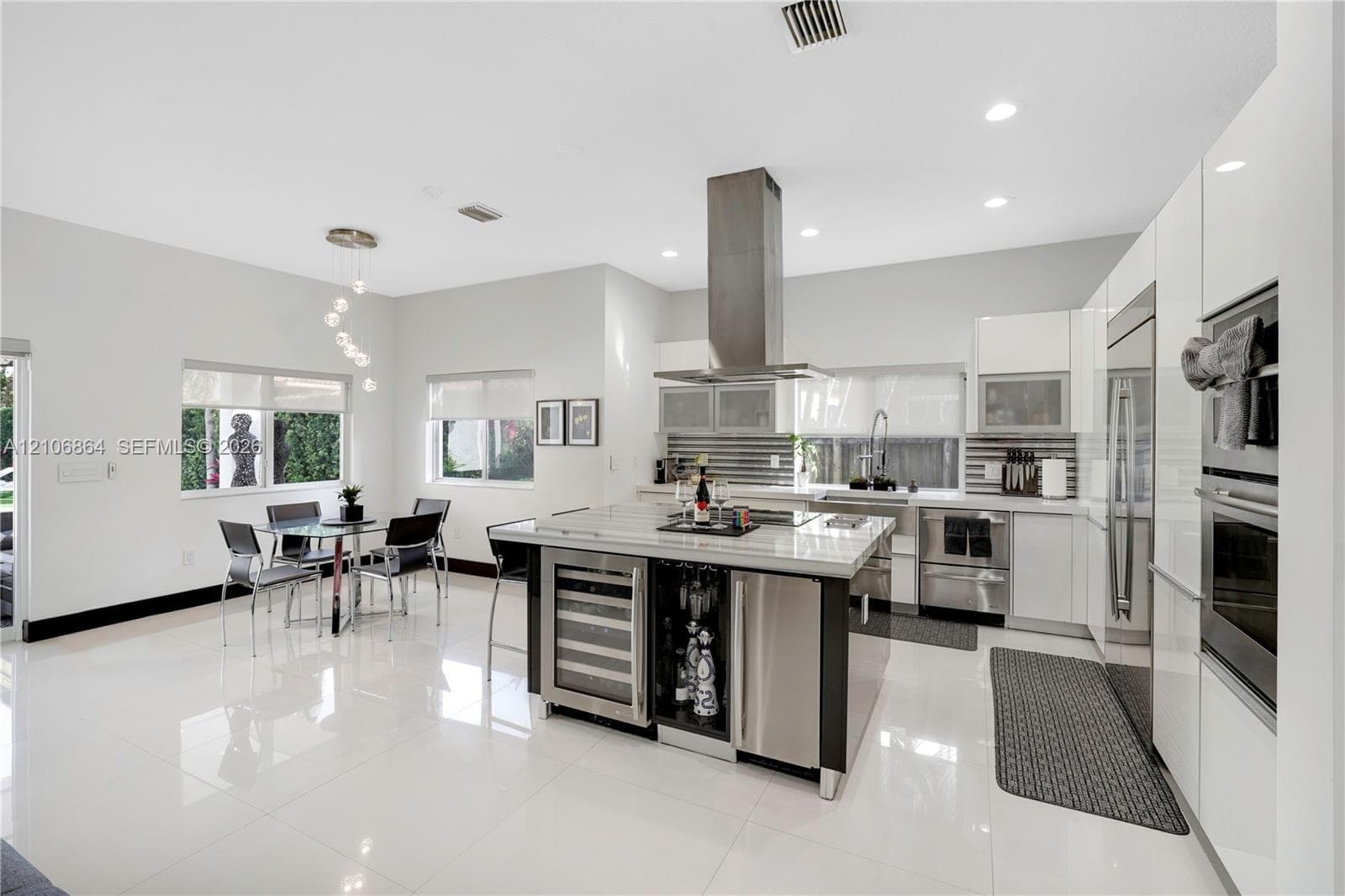 Spacious room featuring high ceilings with recessed tray lighting, polished tile flooring, and horizontal picture windows