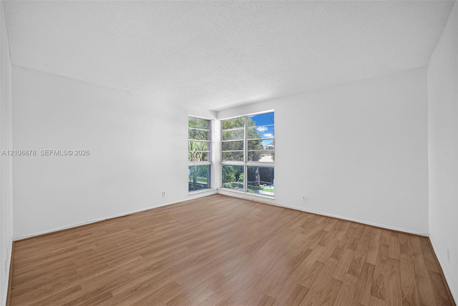 Interior space featuring wood-finish flooring, white walls, and floor-to-ceiling windows with multi-pane glazing