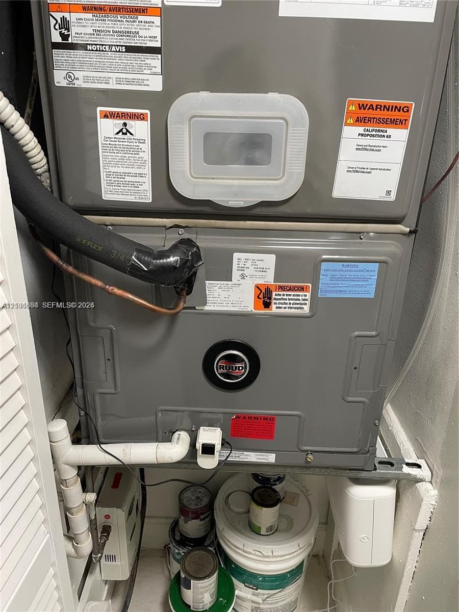 Ruud HVAC unit featuring an insulated coolant line, integrated drain plumbing, and wall-mounted electrical components