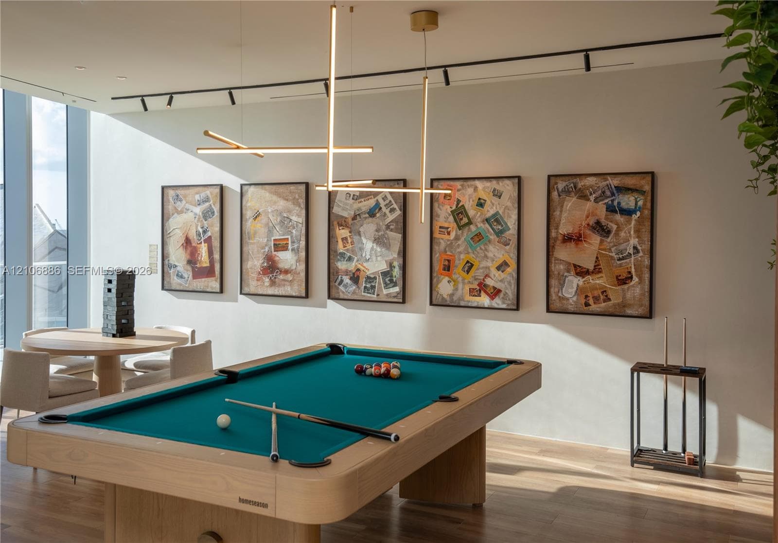 Contemporary linear pendant lighting, black track lighting, and wood-finish flooring