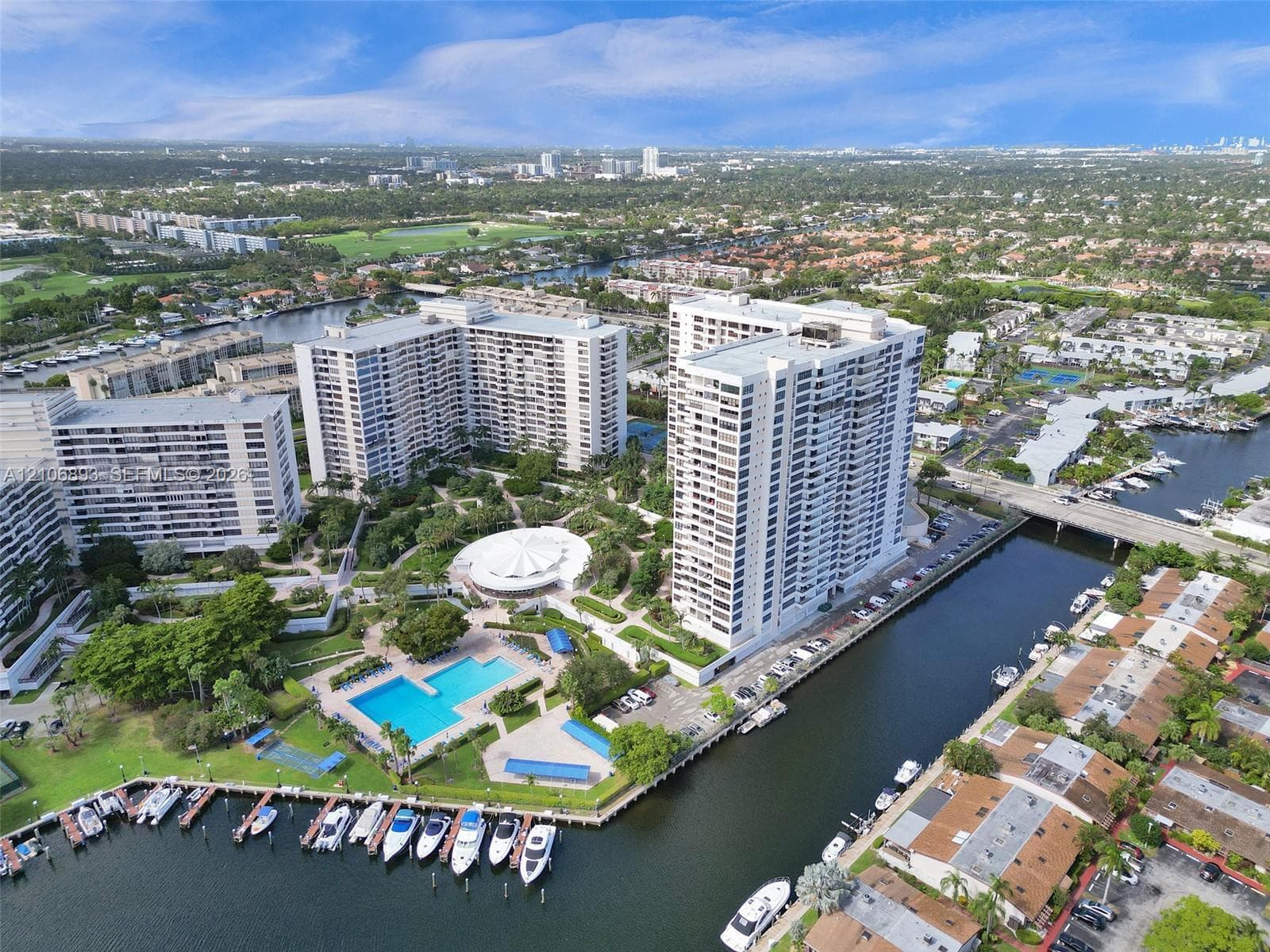 High-rise residential complex featuring a waterfront location with private boat slips, an outdoor swimming pool, and landscaped grounds