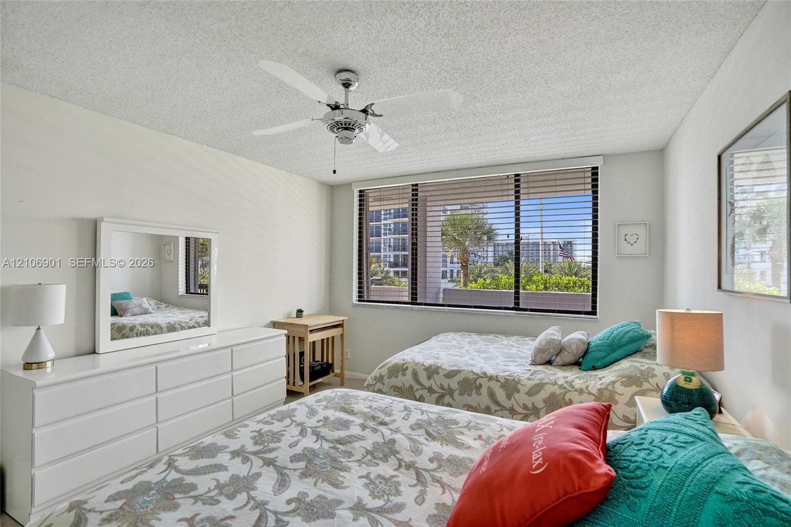 Neutral-toned room featuring a ceiling fan with integrated lighting and a large window with horizontal blinds