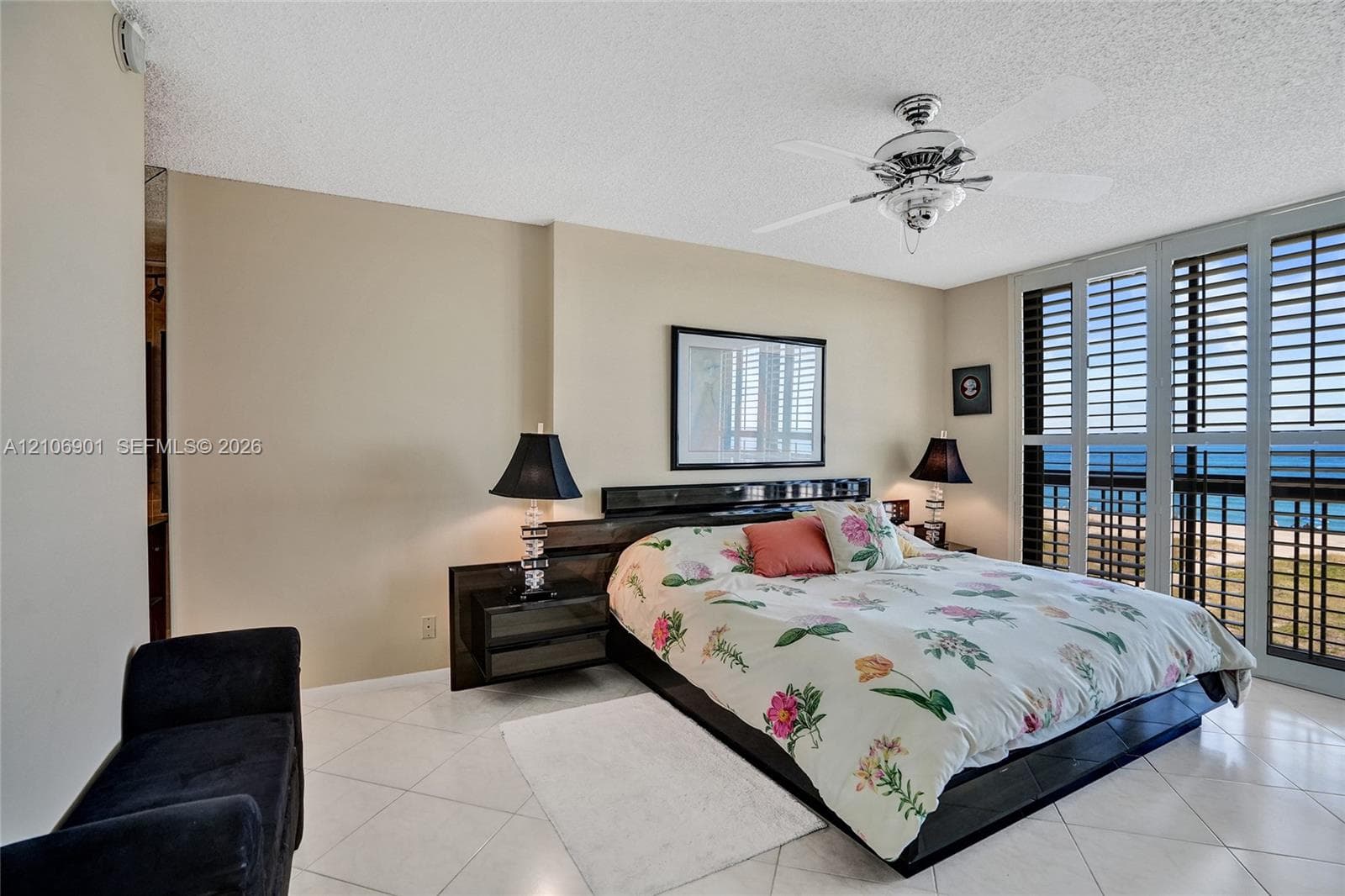 Floor-to-ceiling plantation shutters, neutral tile flooring, and a multi-blade ceiling fan with integrated lighting