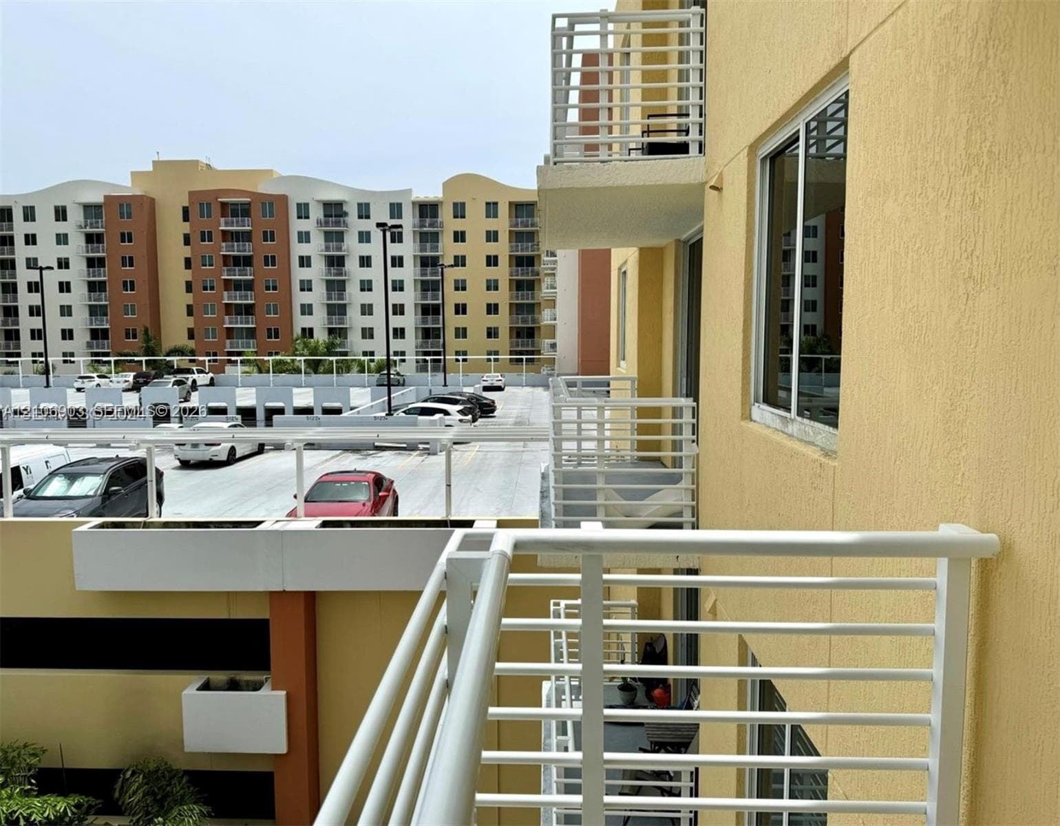 Private balcony featuring a white metal railing and a stucco exterior finish