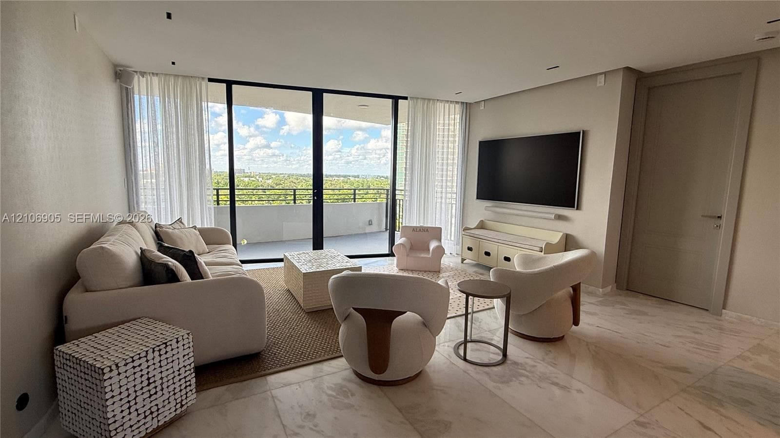 Living area featuring full-height glass sliding doors, stone tile flooring, recessed ceiling lighting, and a neutral color palette