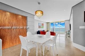Textured wood-panel accent wall, pendant lighting fixture, and floor-to-ceiling glass paneling with water backdrop