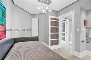 Contemporary interior featuring a multi-light globe chandelier, wood-grain panel doors, glass-paneled interior doors, built-in glass shelving, and neutral-toned flooring