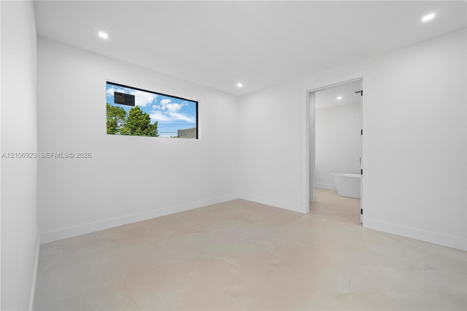 Interior room featuring recessed ceiling lighting, large-format tile flooring, and a horizontal window with a black frame