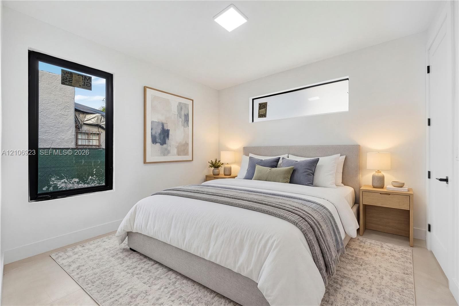 Neutral interior space featuring high-contrast black-framed windows, a horizontal transom window, recessed ceiling lighting, and hard-surface flooring