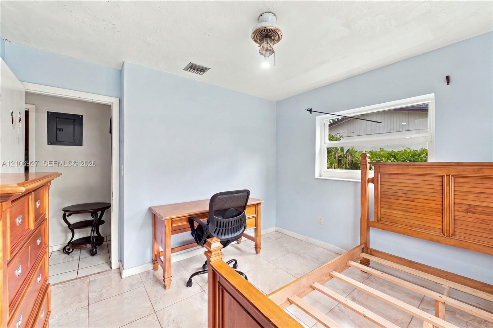 Neutral-toned wall finish, large-format tile flooring, and single-hung window with a metal curtain rod