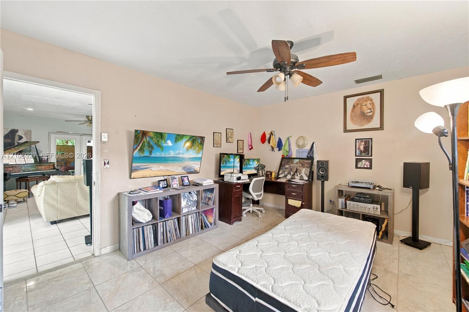 Neutral-toned interior featuring large-format ceramic tile flooring and a ceiling-mounted fan with integrated lighting