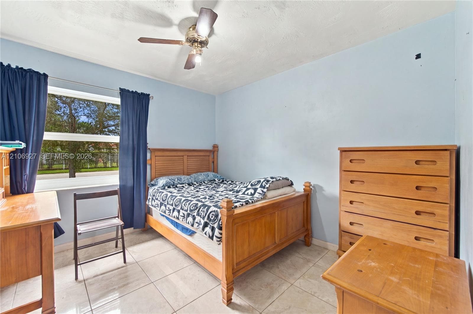 Room featuring large-format tile flooring, a multi-pane window, and a ceiling fan with integrated lighting