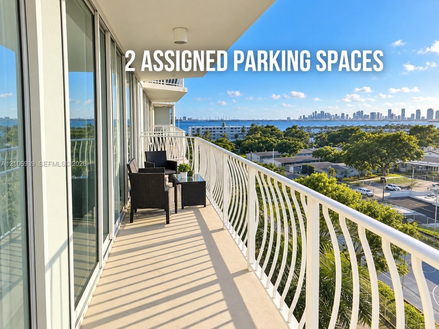 Covered balcony featuring a white metal railing, floor-to-ceiling glass sliding doors, and water-fronting scenery