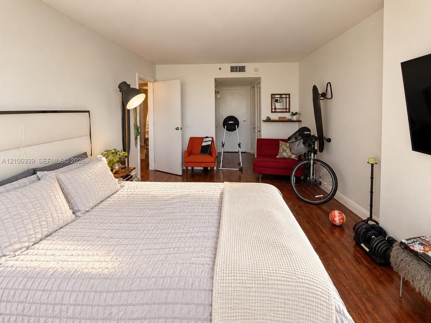 Room featuring dark wood-finish flooring, a wall-mounted floating wood shelf, and neutral wall tones