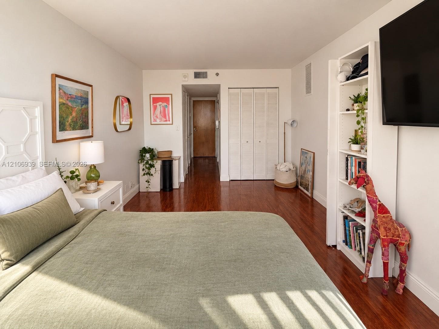 Bedroom interior featuring wood-finish flooring and a closet with bifold doors