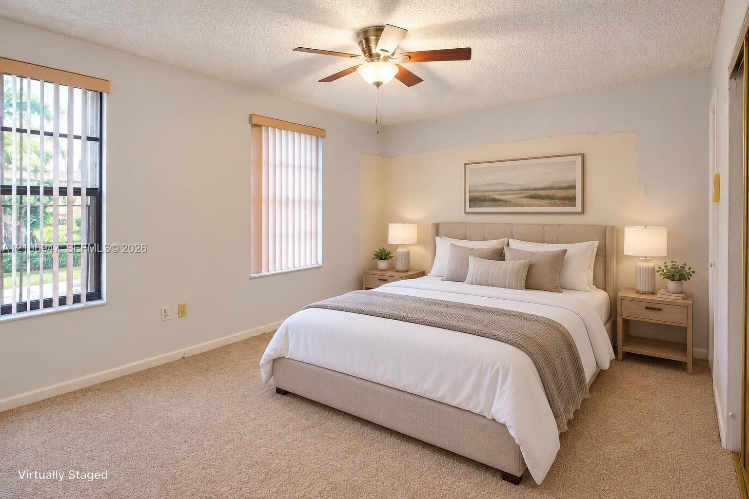 Bedroom featuring wall-to-wall carpeting, dual windows with vertical blinds, and a central ceiling fan with an integrated light fixture