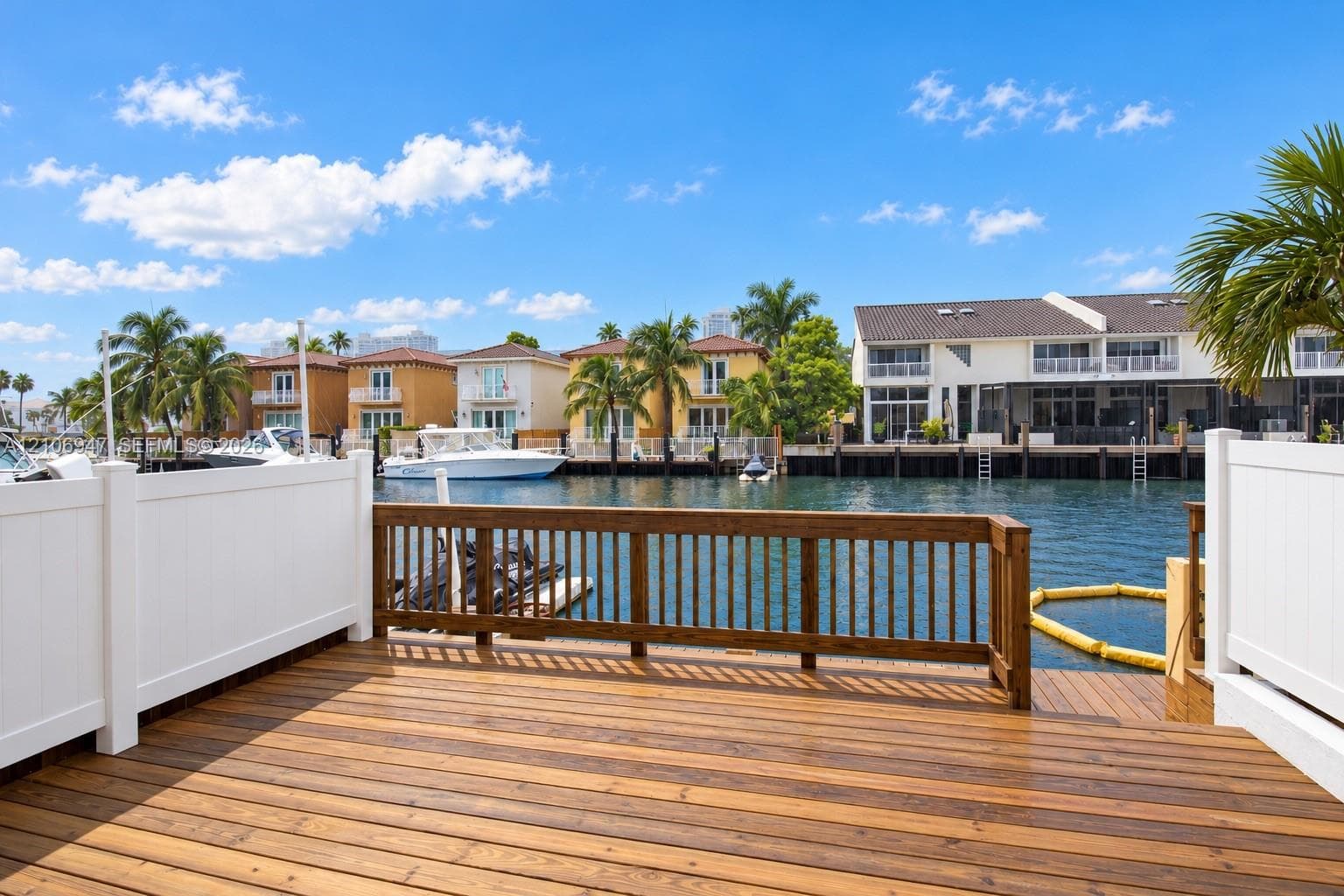 Waterfront deck with wood-finish decking, privacy fencing, and wood railings