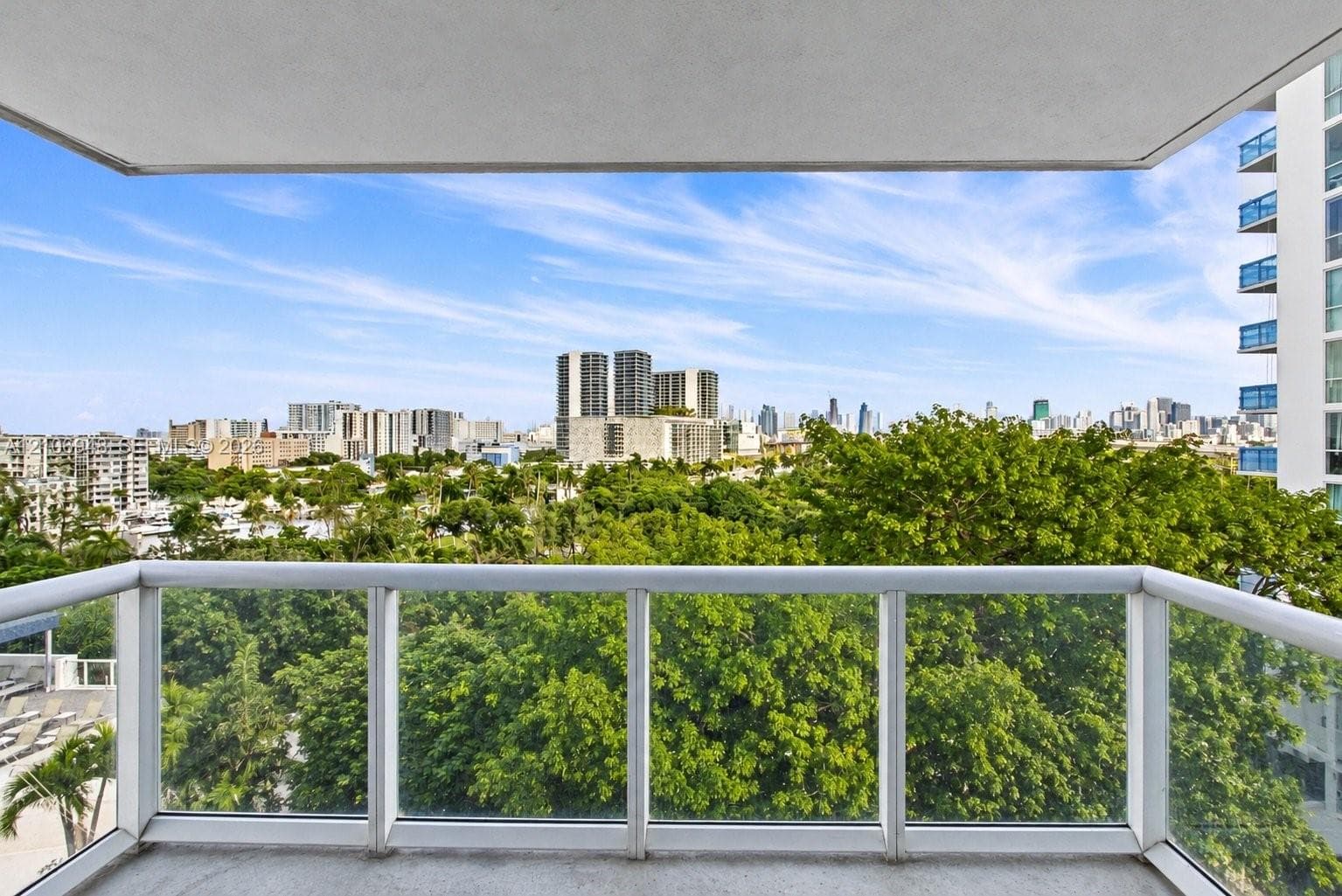 Open-concept space featuring polished tile flooring, contemporary circular LED light fixtures, floor-to-ceiling glass paneling, and an expansive balcony