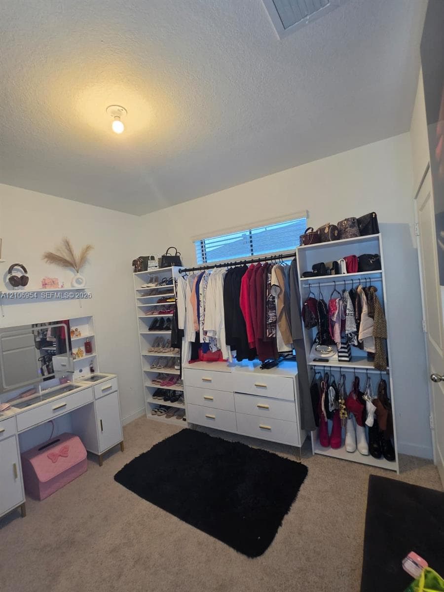 Room featuring neutral wall-to-wall carpeting and a window with horizontal blinds