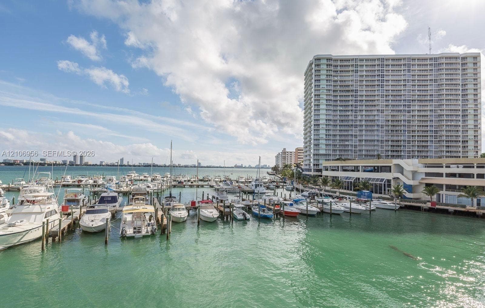 High-rise residential building featuring a deep-water marina with private boat slips and concrete dock infrastructure