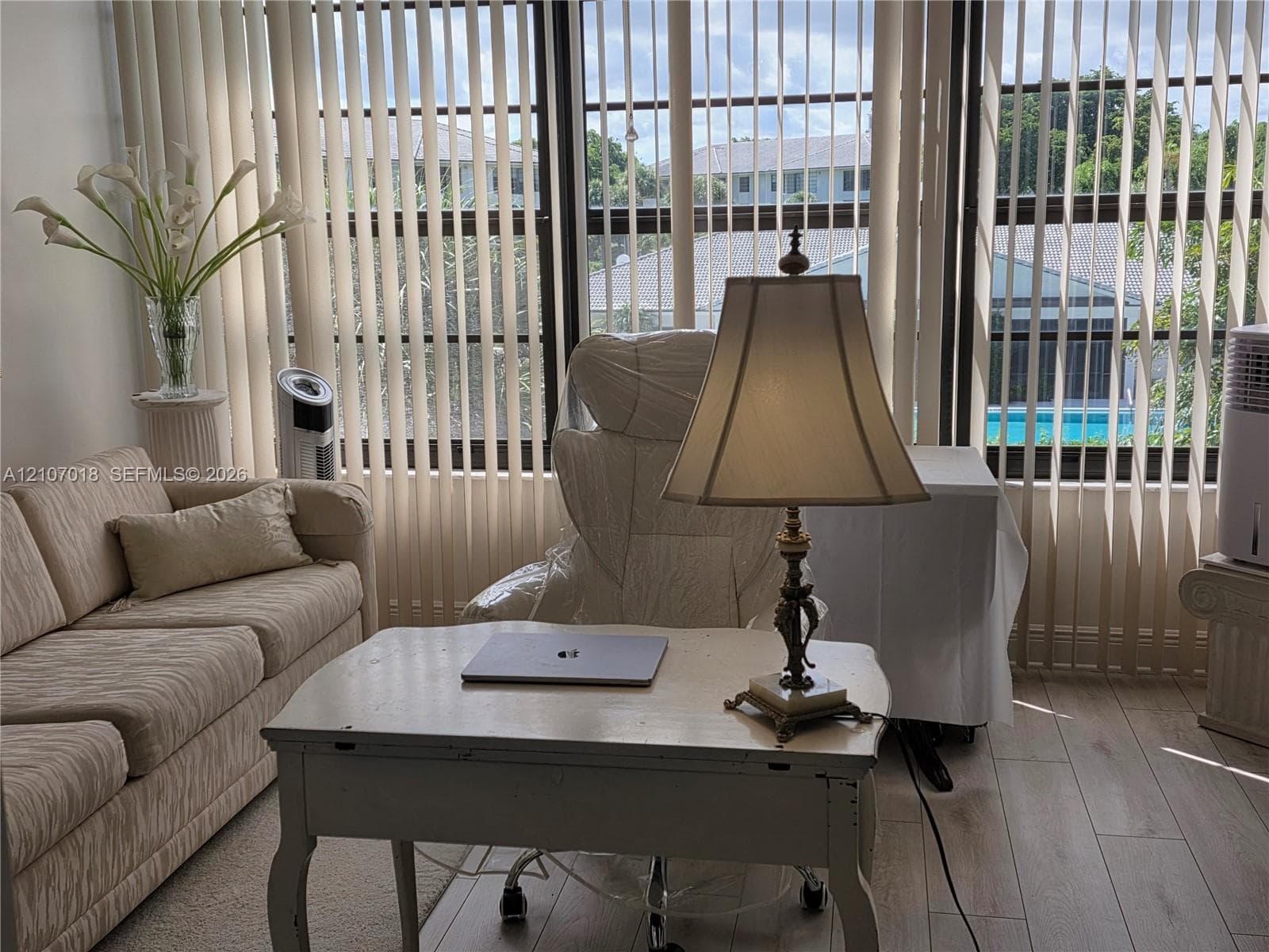 Floor-to-ceiling windows featuring vertical blinds and light-toned wood-finish flooring