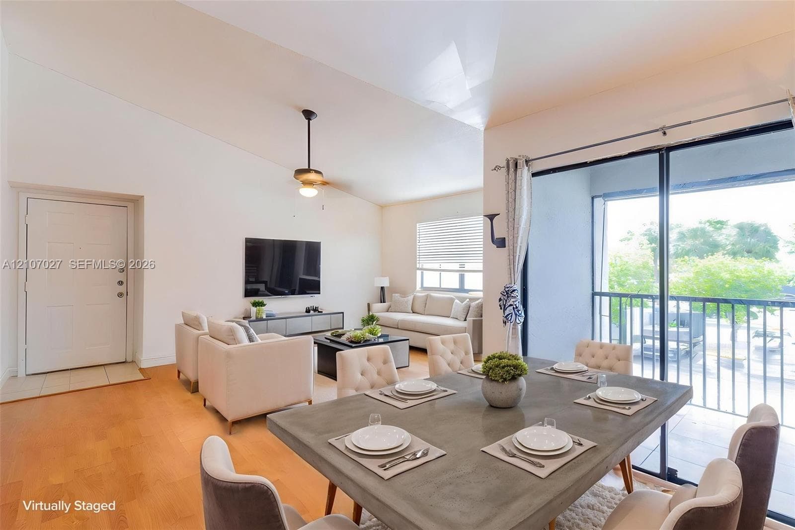 Vaulted ceilings, wood-finish flooring, ceiling fan, and sliding glass doors with access to a balcony