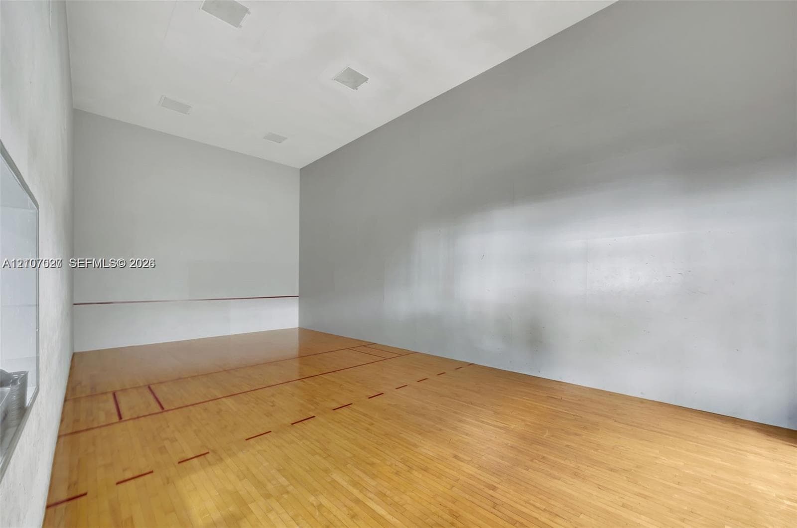 Recreational court featuring wood-finish flooring, high ceilings with recessed lighting, and smooth-finish wall surfaces