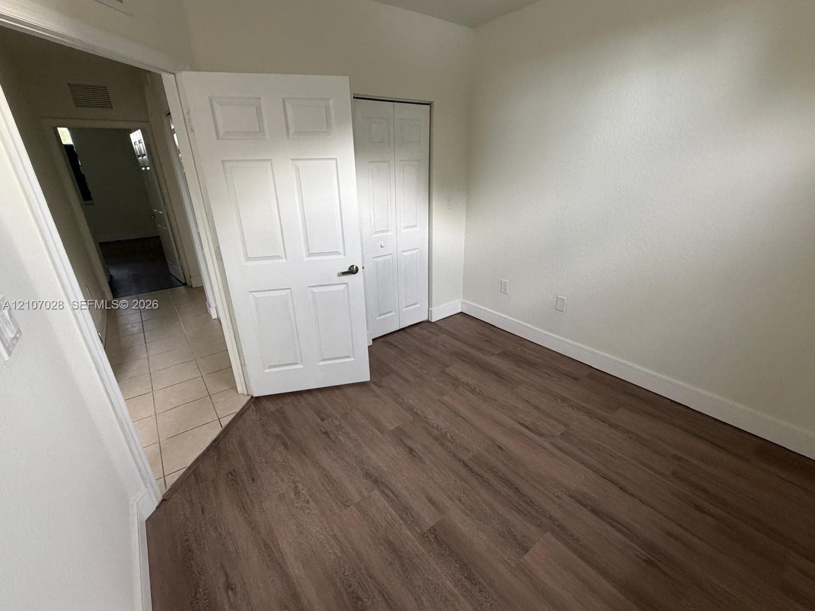 Interior space featuring wood-finish flooring, six-panel interior doors, and a bi-fold closet door