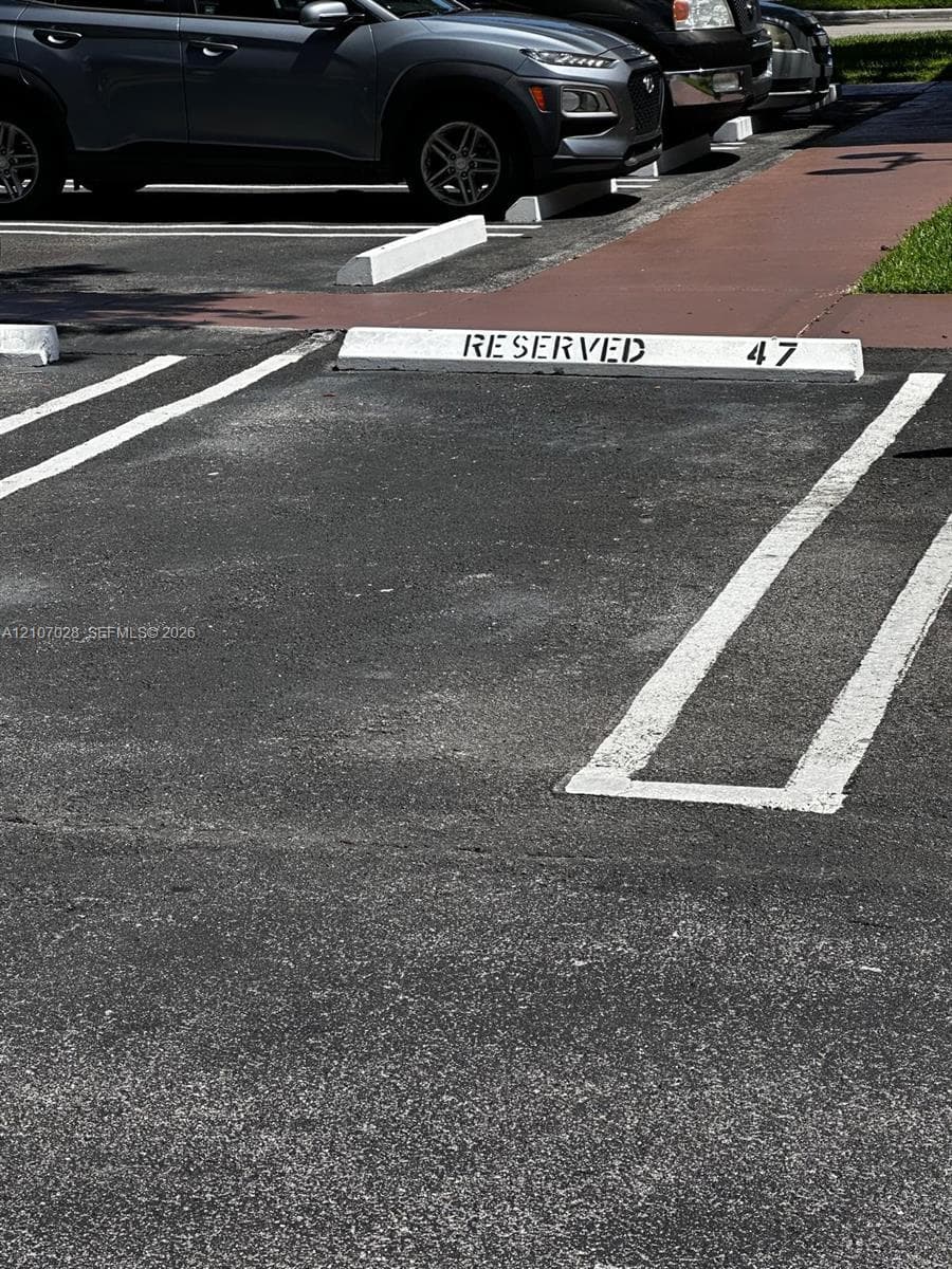 Assigned parking space featuring painted concrete wheel stops and clearly marked pavement striping
