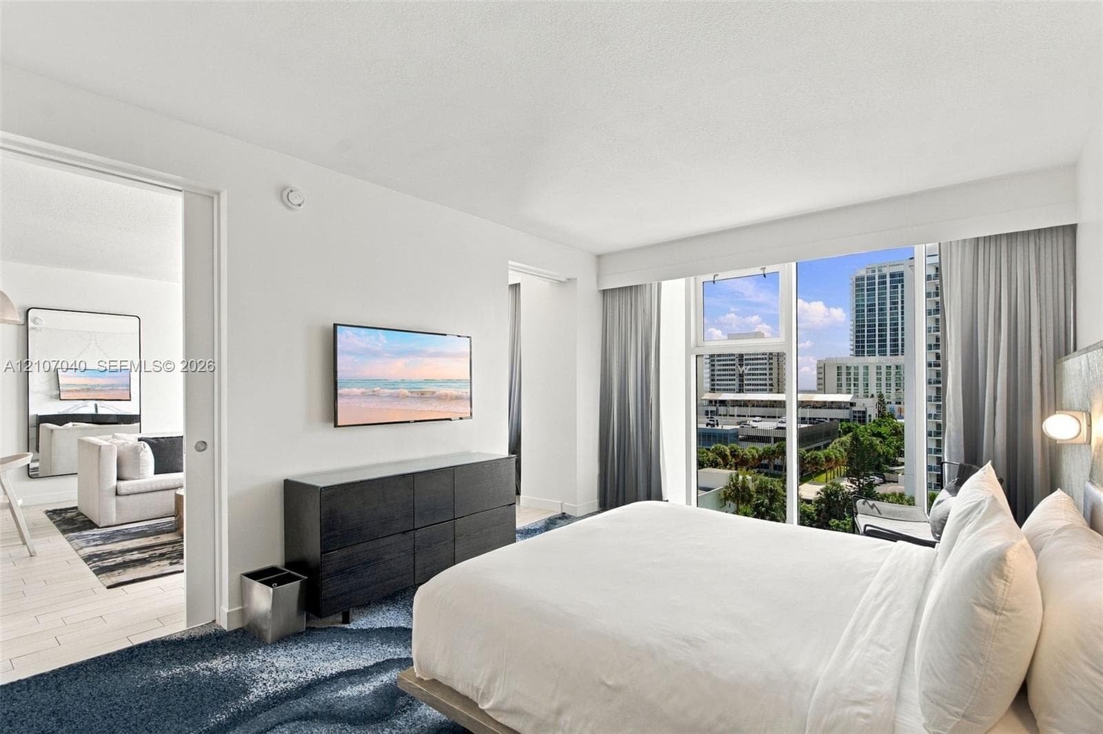 Floor-to-ceiling windows, sliding pocket door, wood-finish flooring, and wall-mounted light fixtures