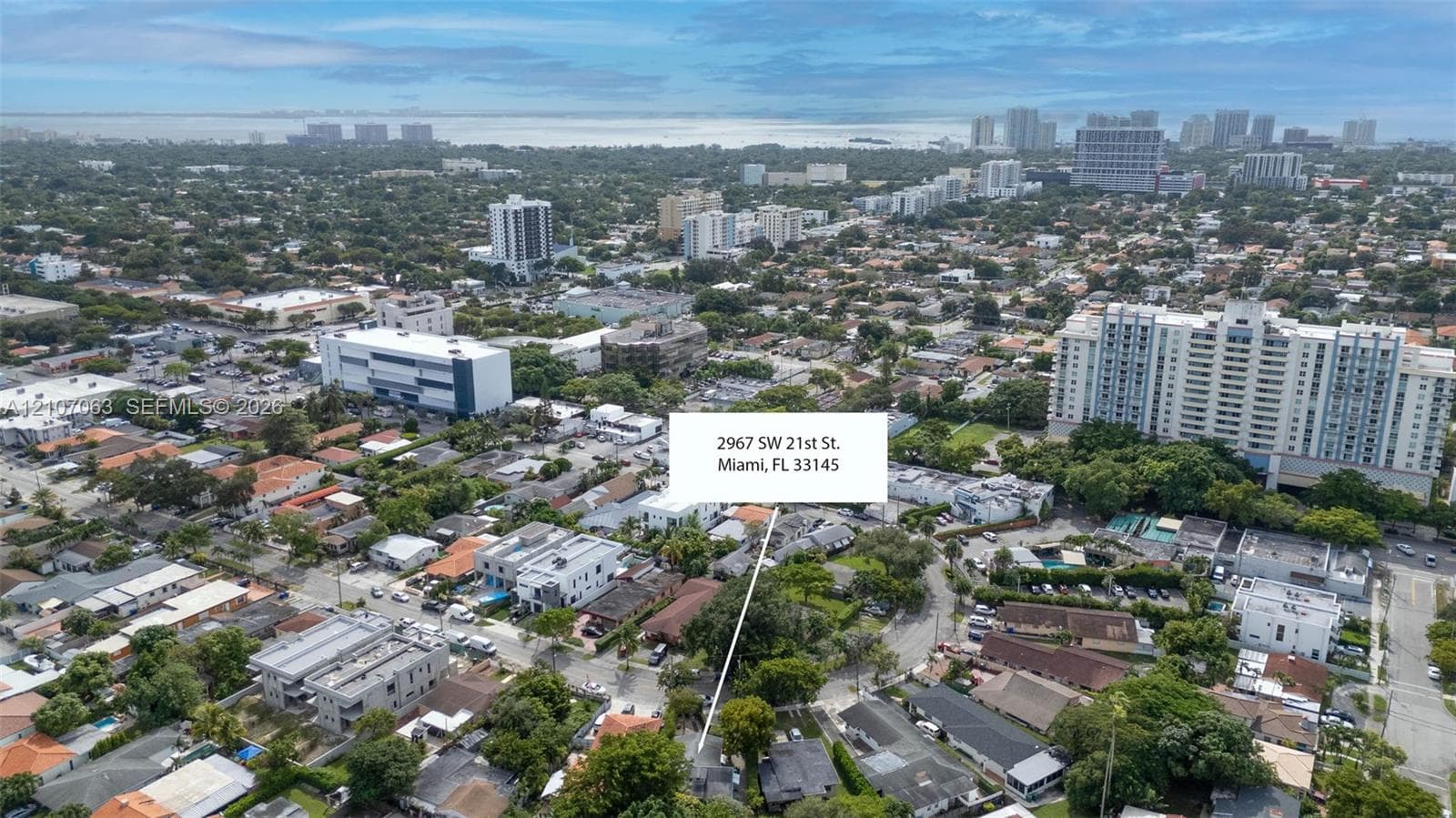 Aerial perspective of the property located in Miami, featuring surrounding urban infrastructure, established tree canopy, and proximity to the coastline