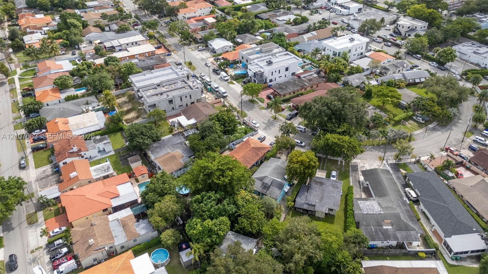 Aerial perspective featuring mature trees, established residential streets, and a varied neighborhood layout