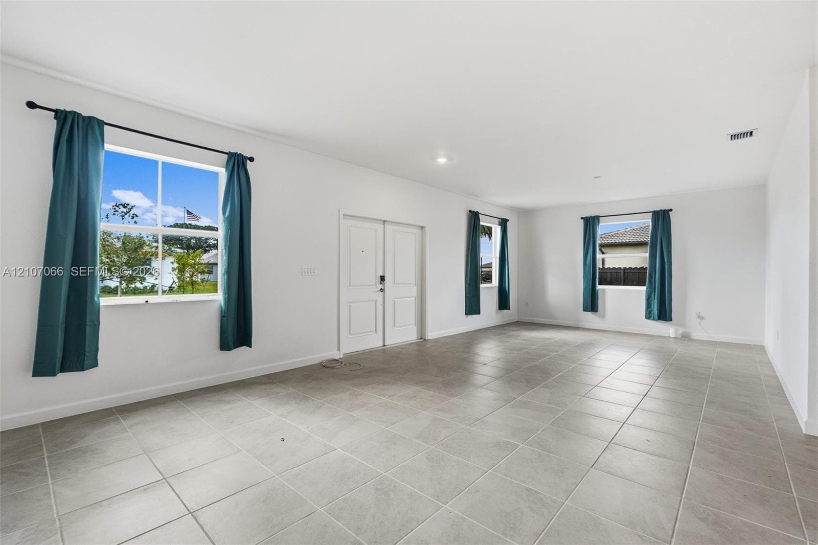 Spacious interior featuring neutral tile flooring, recessed lighting, and expansive windows