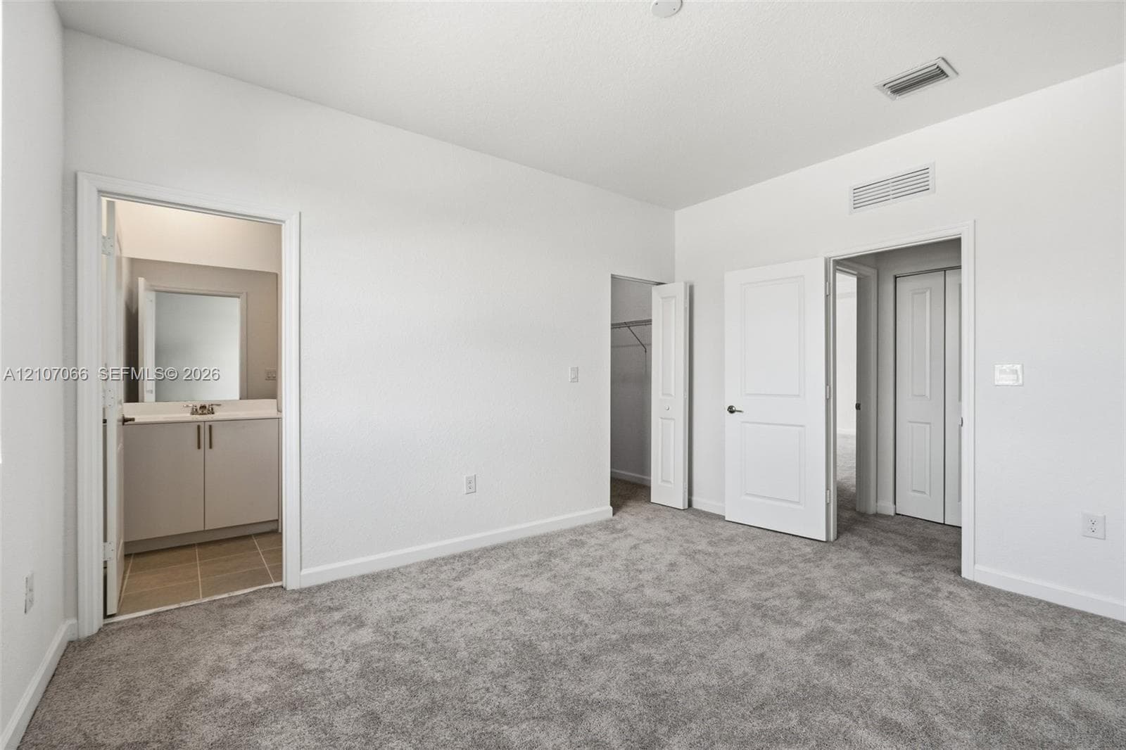 Neutral wall tones with gray carpeting, multi-panel interior doors, and a built-in closet