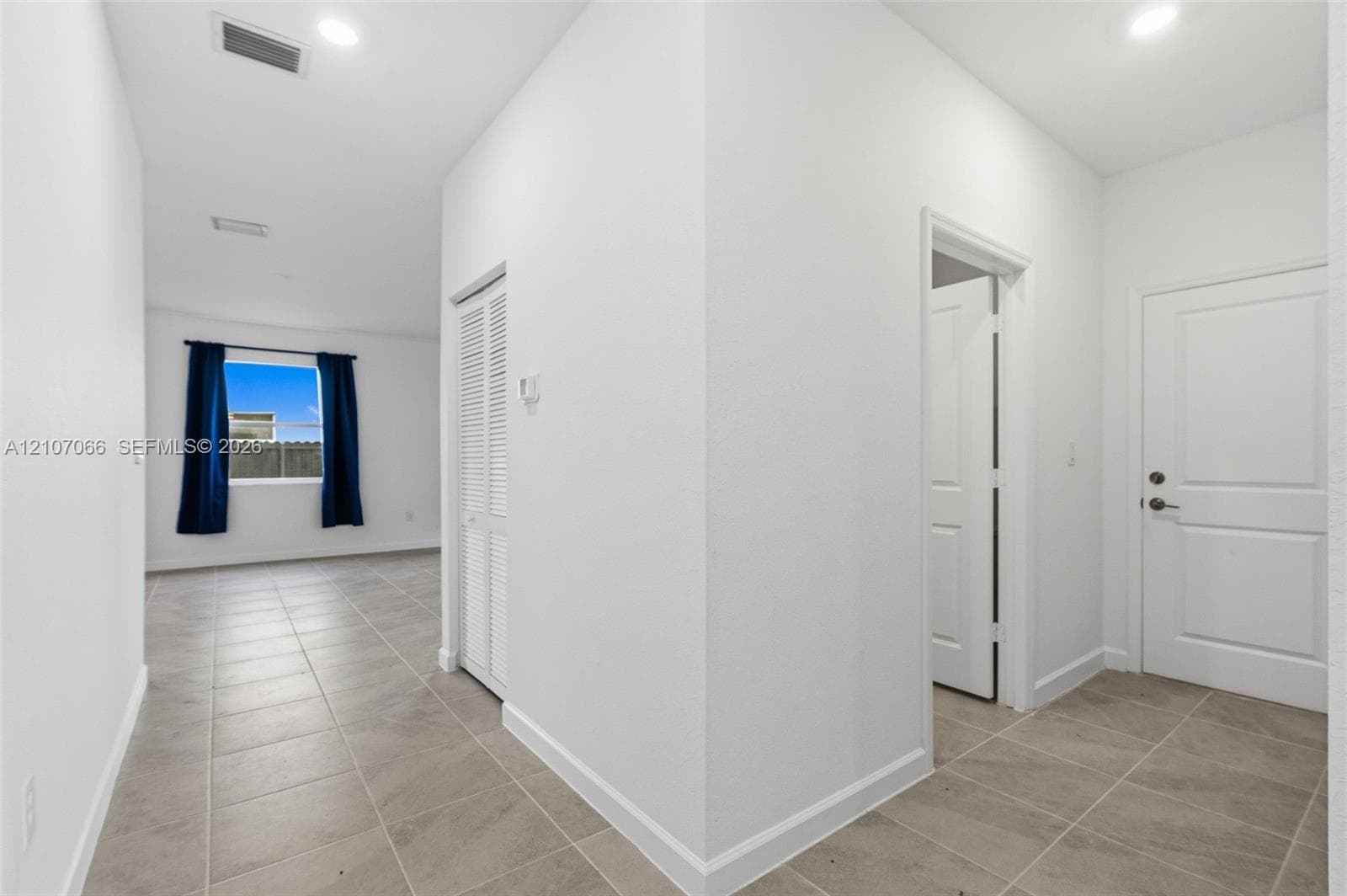 Neutral tile flooring, recessed lighting, white panel interior doors, and a bi-fold closet