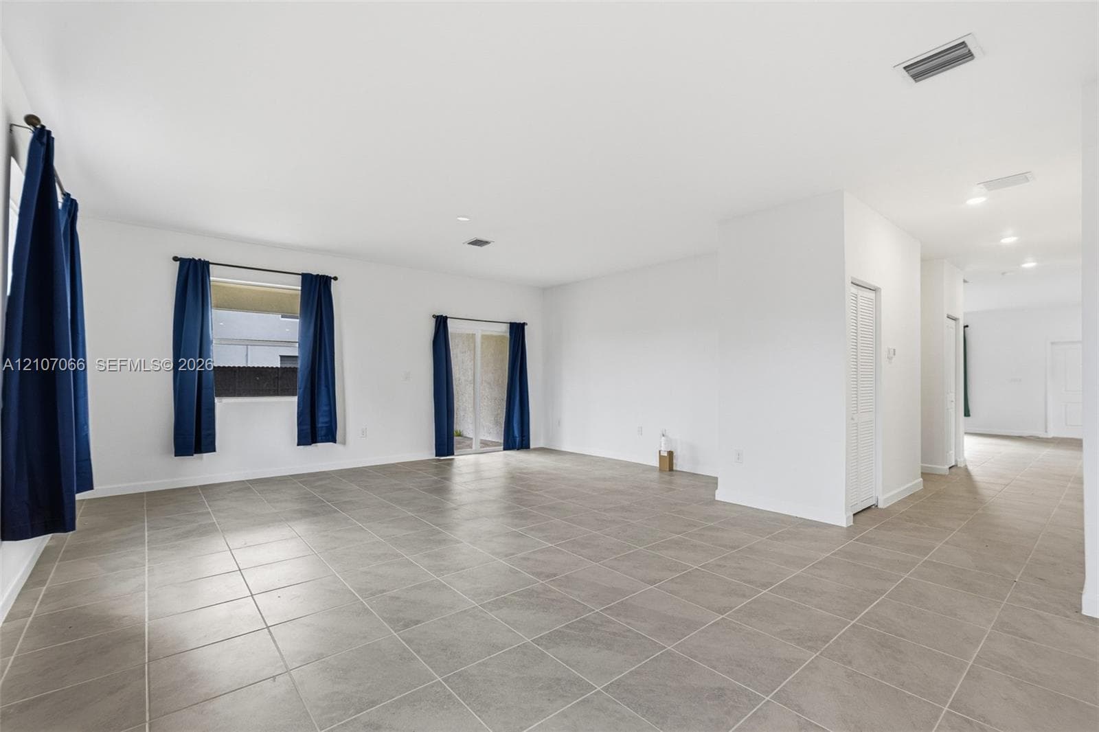 Open floor plan featuring tile flooring, recessed lighting, and sliding glass doors