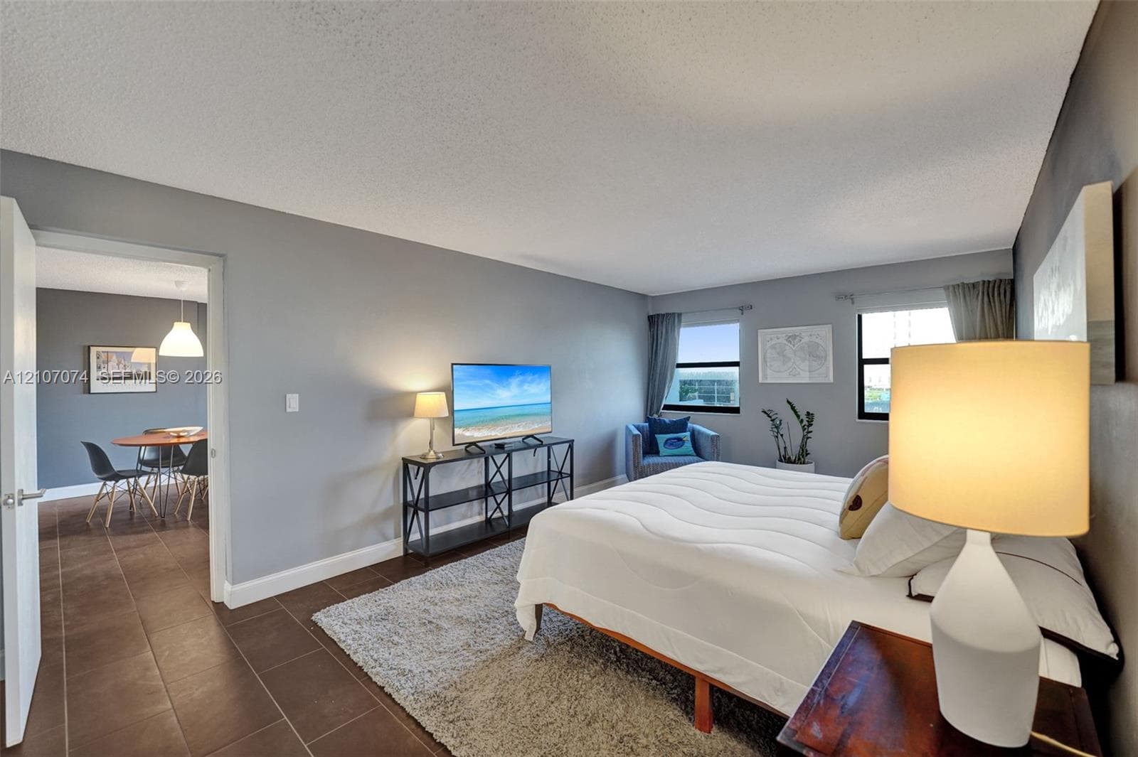 Spacious room featuring neutral wall tones, large windows, and tile flooring
